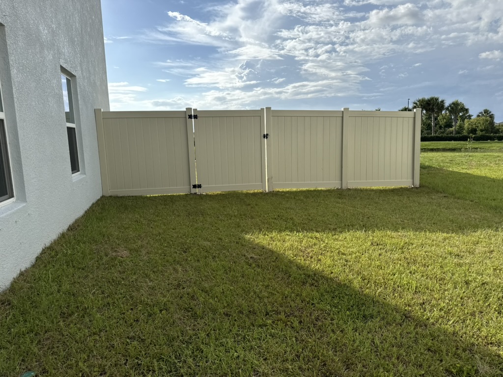 Tan vinyl privacy fence with double gate