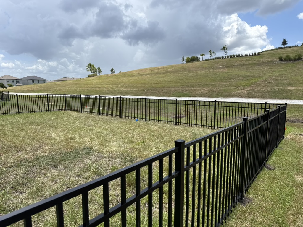 Black aluminum fence on an open backyard lot