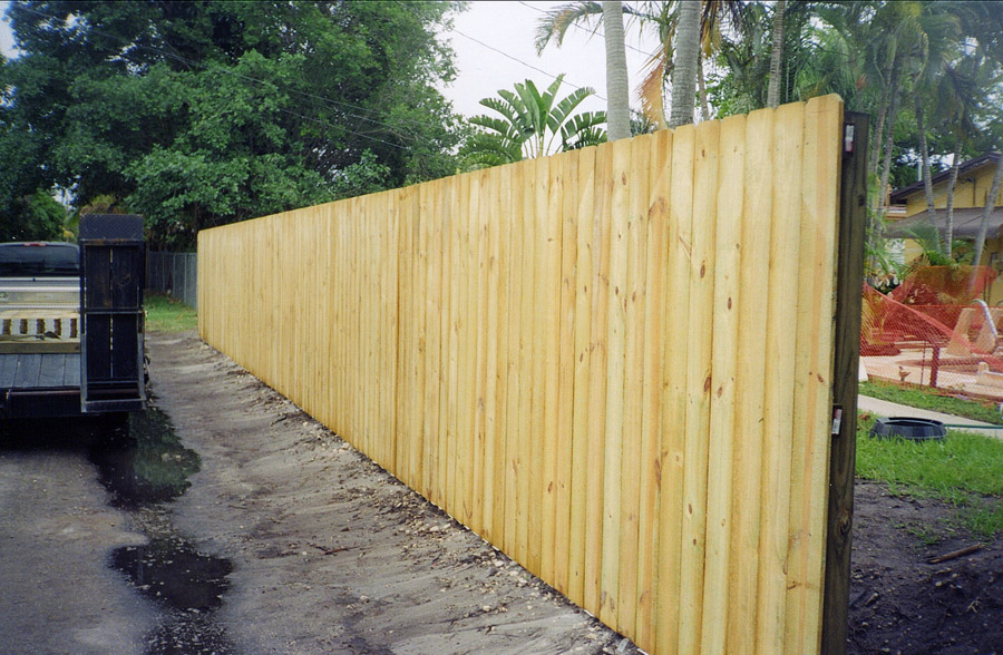 Long pressure-treated wood privacy fence