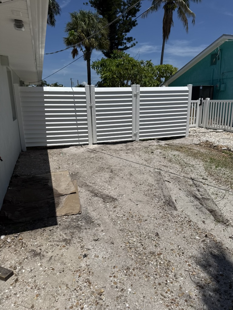 White louvered vinyl fence and gates near the beach